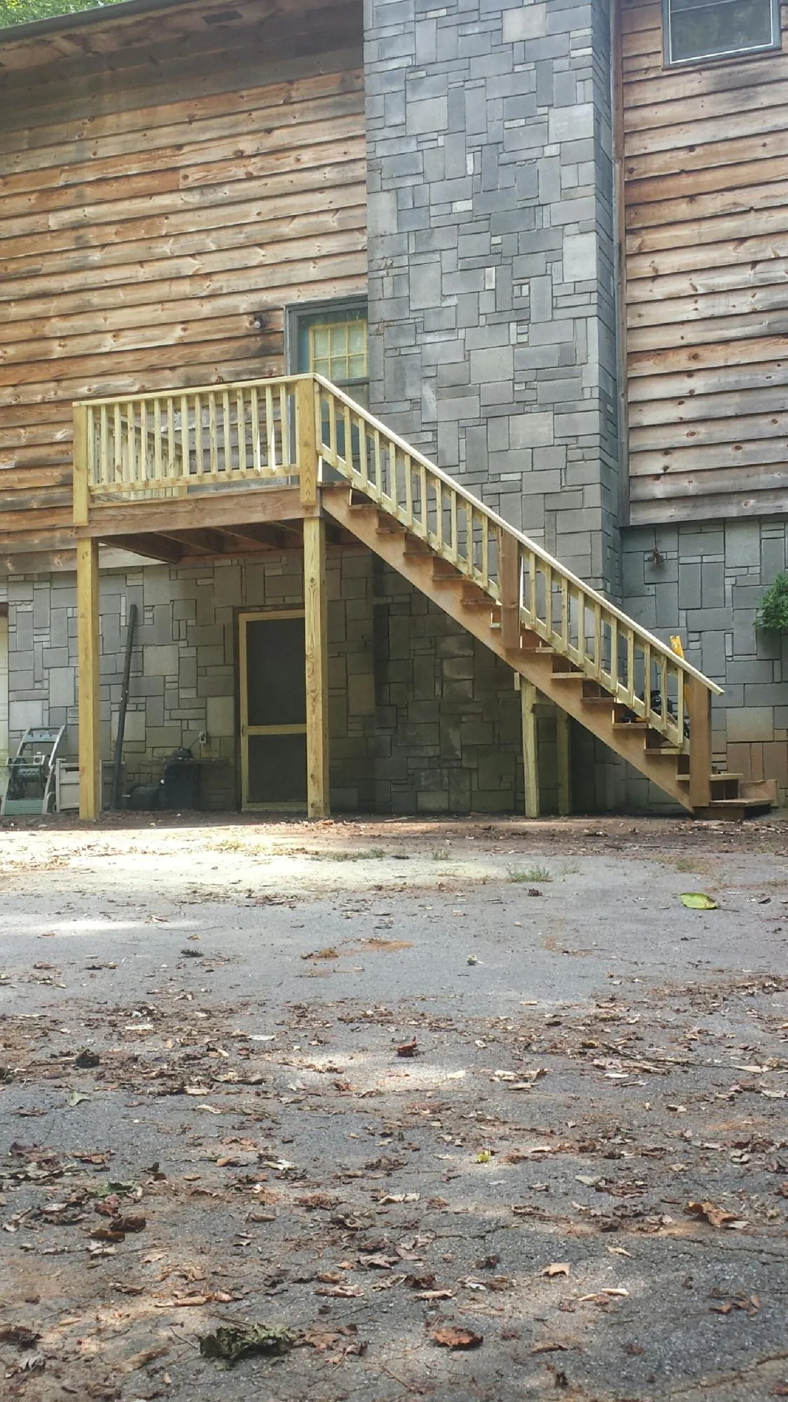 New pressure treated deck and stair landing on a log home in Shirleysburg