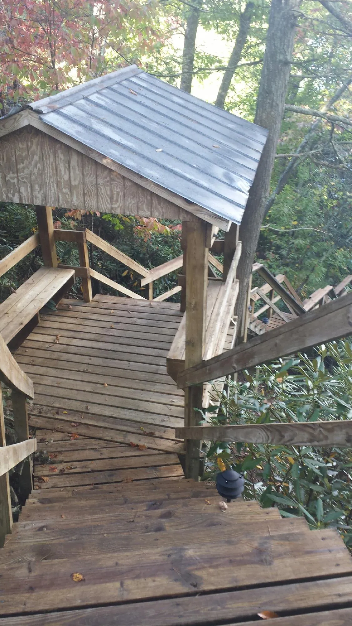 Metal roofed shelter over wooden steps on a wooded walkway — Skylight Repair & Installation work by our crew in Shirleysburg