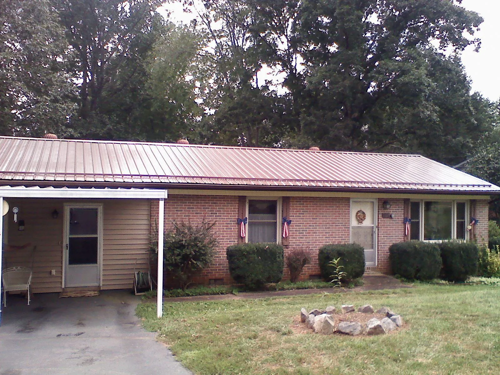 Bronze metal roof and carport on a brick ranch home — Roof Repair work by our crew in Shirleysburg